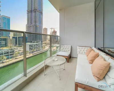 a balcony with a couch and a view of a river at Rustic 2BR at Sparkle Tower 1 Dubai Marina by Deluxe Holiday Homes in Dubai