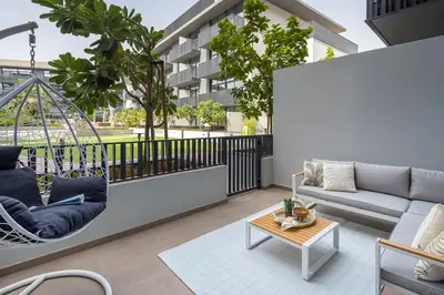 a living room with a swing on a balcony at Frank Porter - Belgravia 3 in Dubai