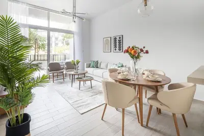 a living room with a table and chairs and a couch at Frank Porter - Belgravia 3 in Dubai