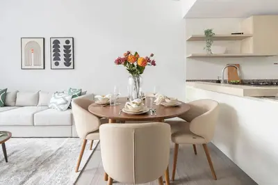 a dining room with a table and chairs and a couch at Frank Porter - Belgravia 3 in Dubai
