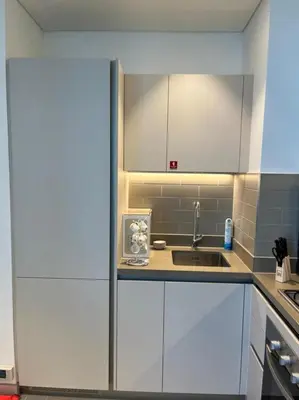a kitchen with white cabinets and a sink at OYO 887 Home A1607 Sobha Creek Vistas - 1BR in Dubai