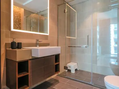 a bathroom with a sink and a glass shower at OYO 755 Home Sobha Greens in Dubai