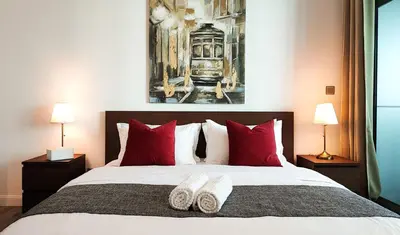 a bedroom with a large bed with red pillows at La Buena Vida Holiday Homes - Luxe 1BD, boutique apt full lakeview 1m to Metro, Lake & Almas Tower in Dubai