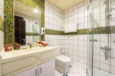 a bathroom with a toilet and a sink and a shower at La Buena Vida Holiday Homes - Luxe 1BD, boutique apt full lakeview 1m to Metro, Lake & Almas Tower in Dubai