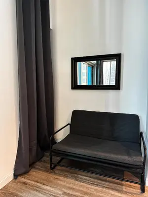 a black bench in a room with a mirror at La Buena Vida Holiday Homes - Luxe 1BD, boutique apt full lakeview 1m to Metro, Lake & Almas Tower in Dubai