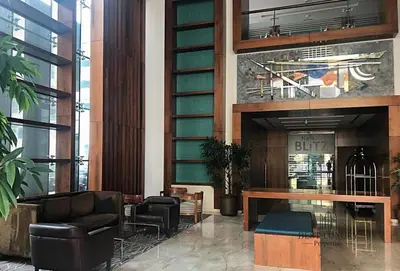 a lobby with two chairs and a table in a building at La Buena Vida Holiday Homes - Luxe 1BD, boutique apt full lakeview 1m to Metro, Lake & Almas Tower in Dubai