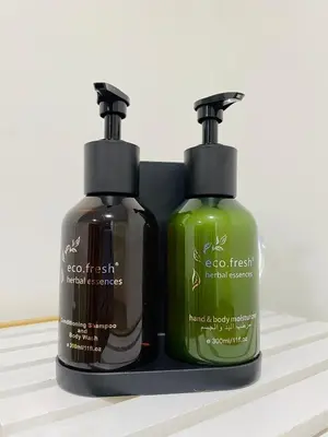 two bottles of detergent are sitting on a shelf at La Buena Vida Holiday Homes - Luxe 1BD, boutique apt full lakeview 1m to Metro, Lake & Almas Tower in Dubai