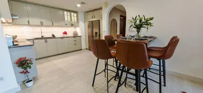 a kitchen with a table and bar stools at La Buena Vida Holiday Homes, Luxe, 3BR with, full kitchen, Marina View, by JBR Beach, Tram & Marina in Dubai