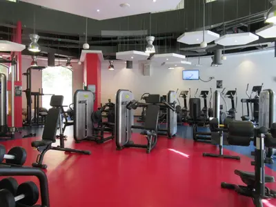a gym with cardio equipment and a red floor at La Buena Vida Holiday Homes, Luxe, 3BR with, full kitchen, Marina View, by JBR Beach, Tram & Marina in Dubai