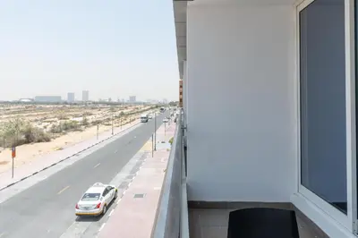 a white car parked on the side of a road at Vacay Lettings - Silicon Oasis Budget Friendly Studio in Dubai