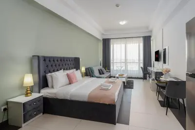 a bedroom with a bed and a desk in a room at Vacay Lettings - Silicon Oasis Budget Friendly Studio in Dubai
