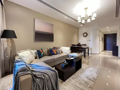 a living room with a couch and a table at Trophy Elite Elegance Suites with Panaromic Burj Khalifa Views in Dubai