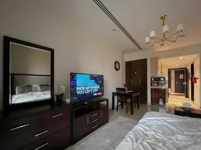 a bedroom with a bed and a flat screen tv at Trophy - Sky High Haven Suite in Dubai