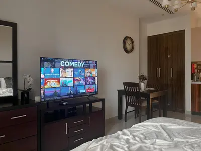 a bedroom with a bed and a flat screen tv at Trophy - Sky High Haven Suite in Dubai
