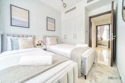 two beds in a bedroom with white walls at Cheerful 3BR Townhouse at DAMAC Hills 2, Dubailand by Deluxe Holiday Homes in Dubai