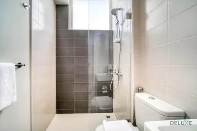 a small bathroom with a toilet and a shower at Cheerful 3BR Townhouse at DAMAC Hills 2, Dubailand by Deluxe Holiday Homes in Dubai