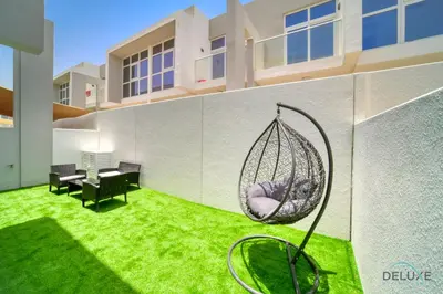 a yard with a hammock in the middle of a building at Cheerful 3BR Townhouse at DAMAC Hills 2, Dubailand by Deluxe Holiday Homes in Dubai