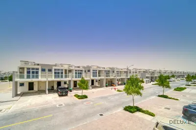 an empty parking lot in front of a building at Cheerful 3BR Townhouse at DAMAC Hills 2, Dubailand by Deluxe Holiday Homes in Dubai
