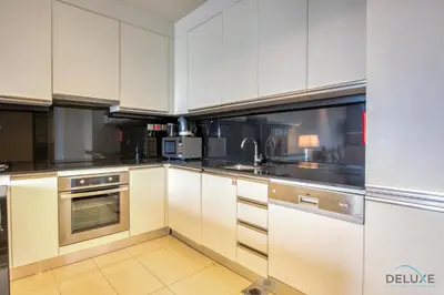 a kitchen with white cabinets and stainless steel appliances at Lush 1 BR at The Address Residences Dubai Marina by Deluxe Holiday Homes in Dubai