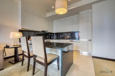 a kitchen with white cabinets and a table and chairs at Lush 1 BR at The Address Residences Dubai Marina by Deluxe Holiday Homes in Dubai