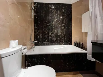 a bathroom with a toilet and a bath tub and a toilet at Trophy Stays - Supreme Sunrise Suites w Burj Khalifa view - Studio in Dubai