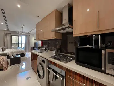 a kitchen with a stove and a microwave at Trophy Stays - Supreme Sunrise Suites w Burj Khalifa view - Studio in Dubai