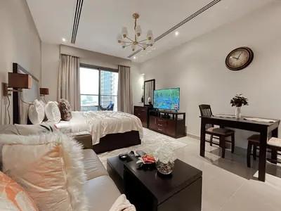 a bedroom with a bed and a desk and a piano at Trophy Stays - Supreme Sunrise Suites w Burj Khalifa view - Studio in Dubai