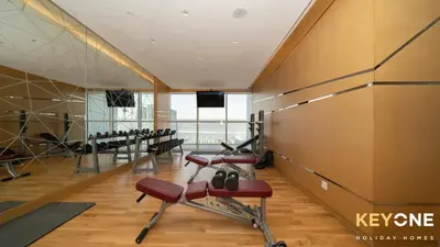 a gym with a row of exercise equipment in a room at Carson Elegant Living in One Bedroom in Dubai