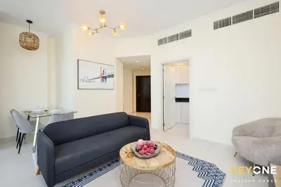 a living room with a couch and a table at Carson Elegant Living in One Bedroom in Dubai