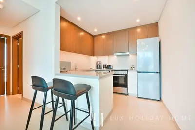 a kitchen with two bar stools and a counter top at LUX 52 42 Deluxe Marina view suite 1 in Dubai