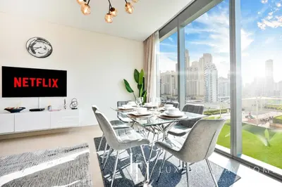 a dining room with a table and chairs and a large window at LUX 52 42 Deluxe Marina view suite 1 in Dubai