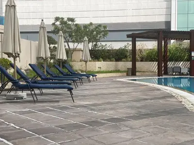 a row of lounge chairs with umbrellas and a pool at Unique 3BR DUPLEX Apartment with Marina Views in Dubai