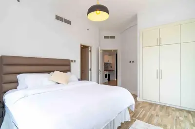 a white bedroom with a large white bed and a light at Unique 3BR DUPLEX Apartment with Marina Views in Dubai