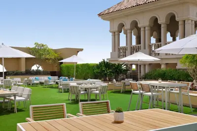an outdoor patio with tables and chairs and umbrellas at Marriott Hotel Al Jaddaf, Dubai in Dubai