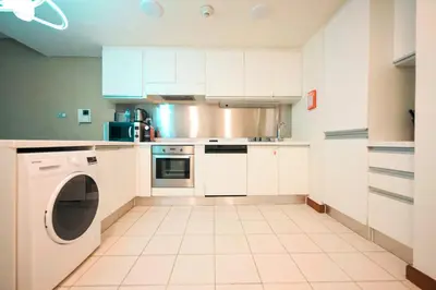a kitchen with white cabinets and a dishwasher at FAHH - Superior 1BHK Address Dubai Mall Residences in Dubai