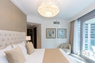 a bedroom with a large bed and a chandelier at Westminster Opera Burj Khalifa in Dubai