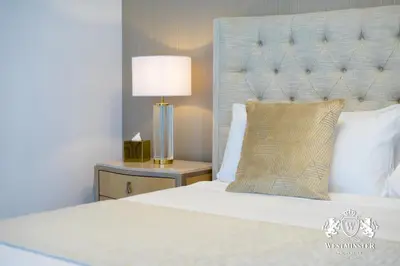 a bedroom with a bed and a lamp on a night stand at Westminster Opera Burj Khalifa in Dubai