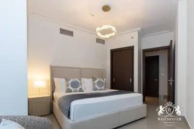 a bedroom with a large white bed with blue pillows at Westminster Opera Burj Khalifa in Dubai