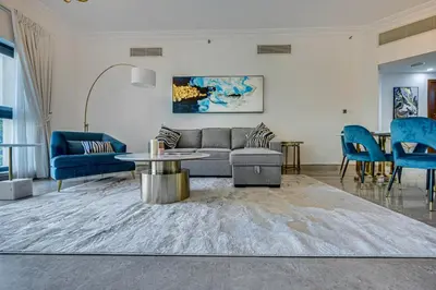 a living room with a couch and blue chairs at Harmony Vacation Homes - North Residence in Dubai
