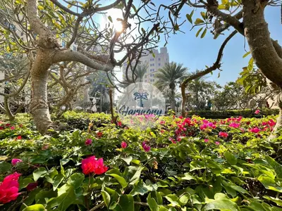 a garden of flowers in front of the disney sign at Harmony Vacation Homes - North Residence in Dubai
