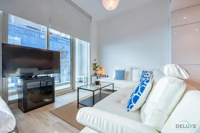 a living room with a white couch and a flat screen tv at Airy Studio in Studio One Dubai Marina by Deluxe Holiday Homes in Dubai