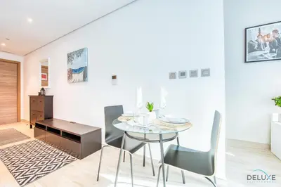 a dining room with a glass table and chairs at Airy Studio in Studio One Dubai Marina by Deluxe Holiday Homes in Dubai