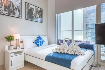 a bedroom with two swans pillows on a bed at Airy Studio in Studio One Dubai Marina by Deluxe Holiday Homes in Dubai
