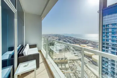 a room with a balcony with a view of the ocean at Airy Studio in Studio One Dubai Marina by Deluxe Holiday Homes in Dubai