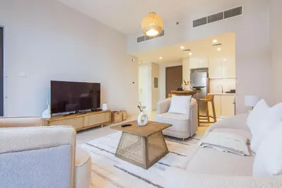 a living room with a couch and a tv at Brand new 1 bedroom apartment Dubai Hills 601 in Dubai