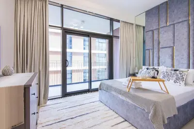 a bedroom with a bed and a large window at Brand new 1 bedroom apartment Dubai Hills 601 in Dubai