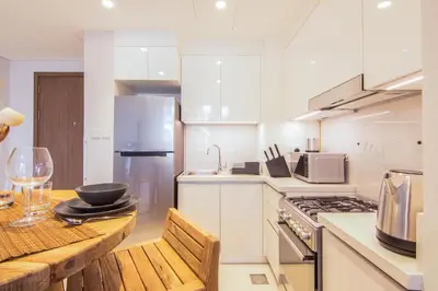 a kitchen with a wooden table and a stove top oven at Brand new 1 bedroom apartment Dubai Hills 601 in Dubai