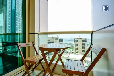 a table and two chairs on a balcony with a view at Luxury Escapes - Furnished studio with balcony in Royal Oceanic in Dubai