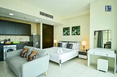 a living room with a couch and a table at Luxury Escapes - Furnished studio with balcony in Royal Oceanic in Dubai