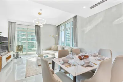 a white living room with a table and chairs at Tropical Home w Private Beach in Emaar Beachfront in Dubai